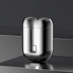 Silberner elektrischer Rasierer mit zwei Scherköpfen auf grauem Hintergrund. Modernes Design, kabellos, ideal für präzise Rasur.